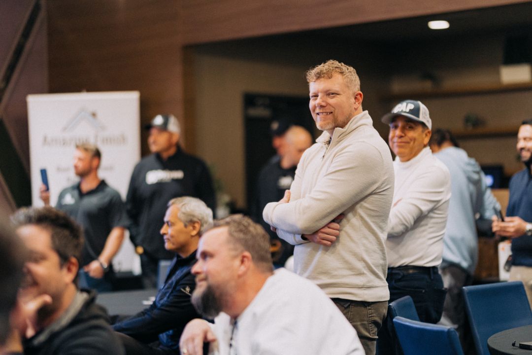 A group of men are standing in a room with their arms crossed.