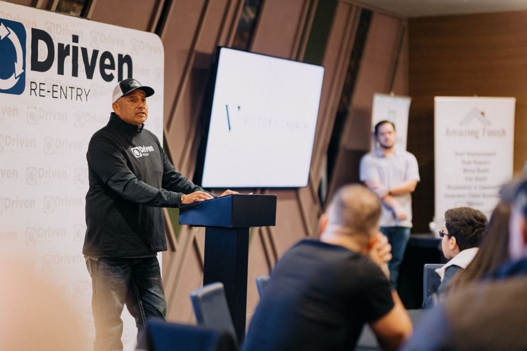 A man is standing at a podium giving a presentation to a group of people.