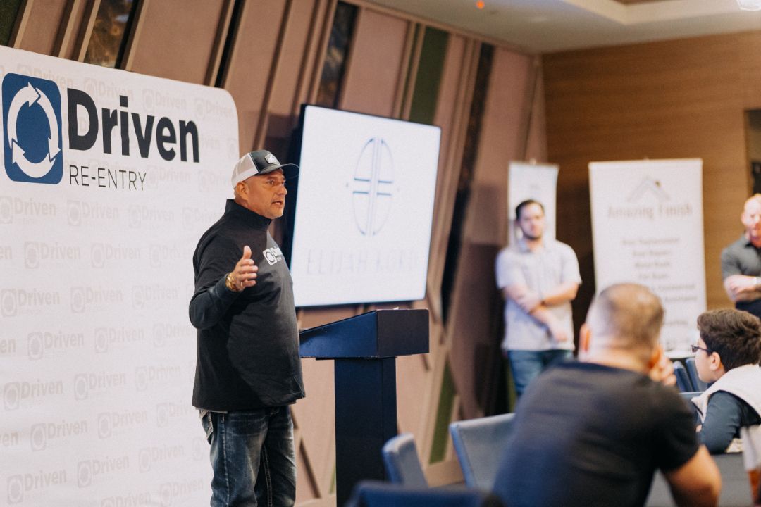 A man is standing at a podium giving a presentation to a group of people.