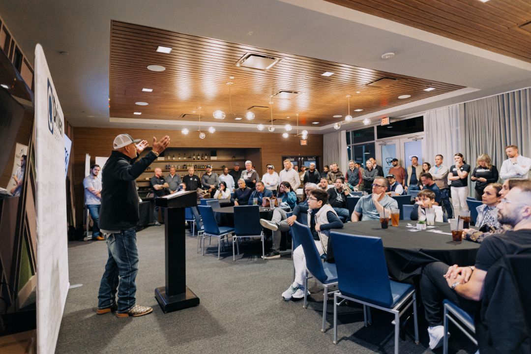A man is standing at a podium in front of a large group of people.