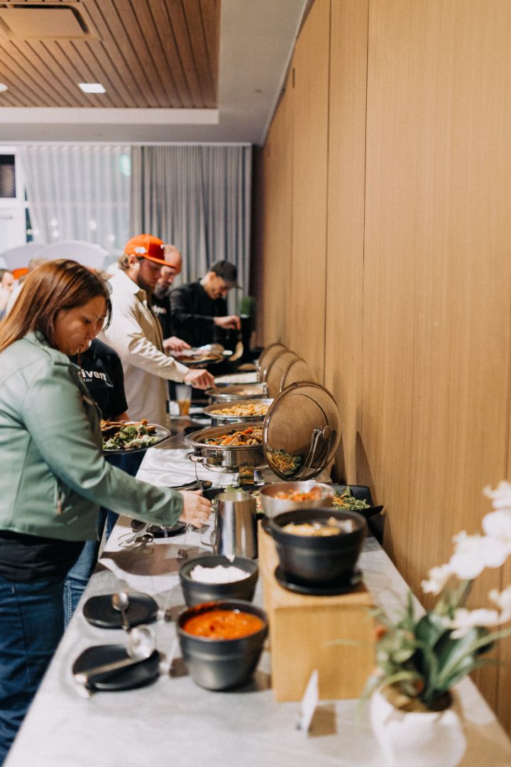 A group of people are standing at a buffet table.