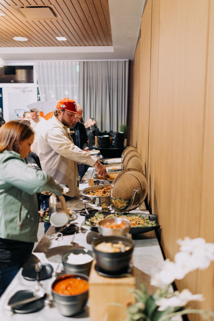 A group of people are standing around a buffet table.