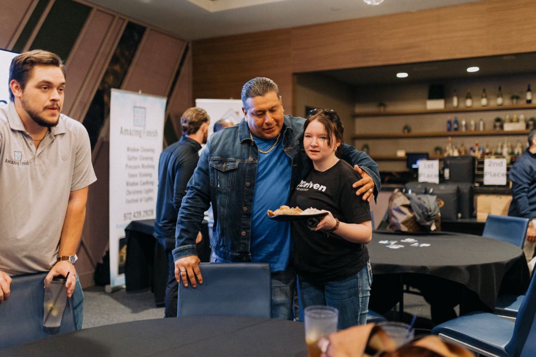 A group of people are standing around a table in a room.