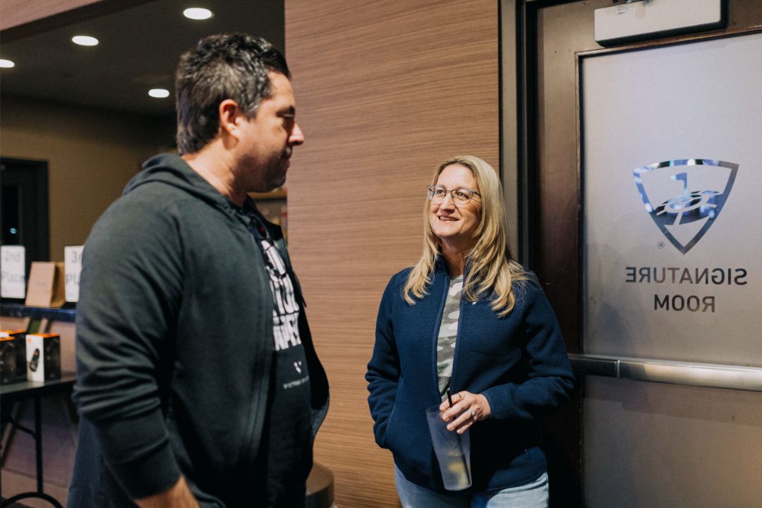 A man and a woman are standing next to each other in front of a door.