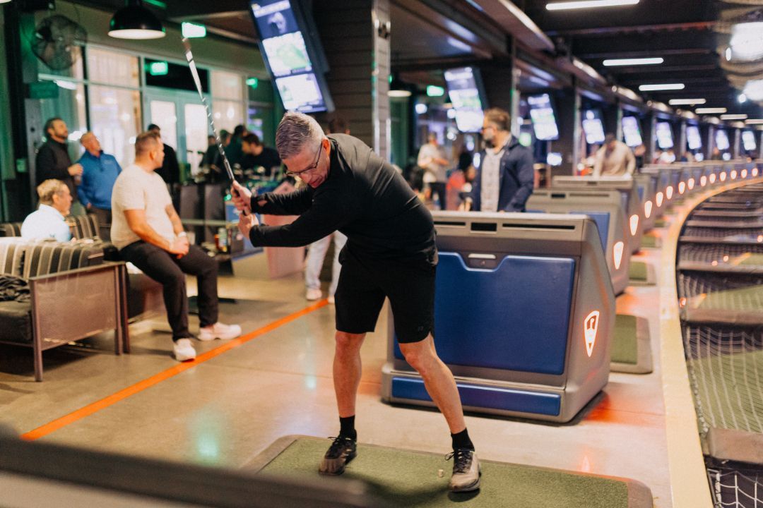 A man is swinging a golf club on a golf course.