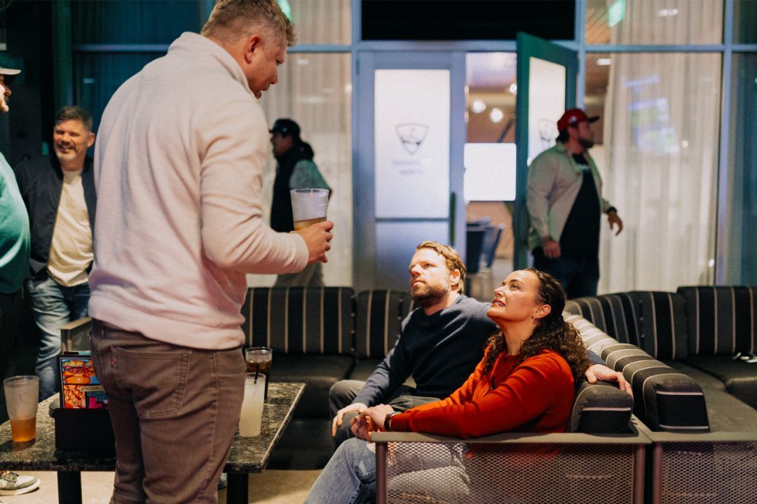 A group of people are sitting on a couch in a living room.
