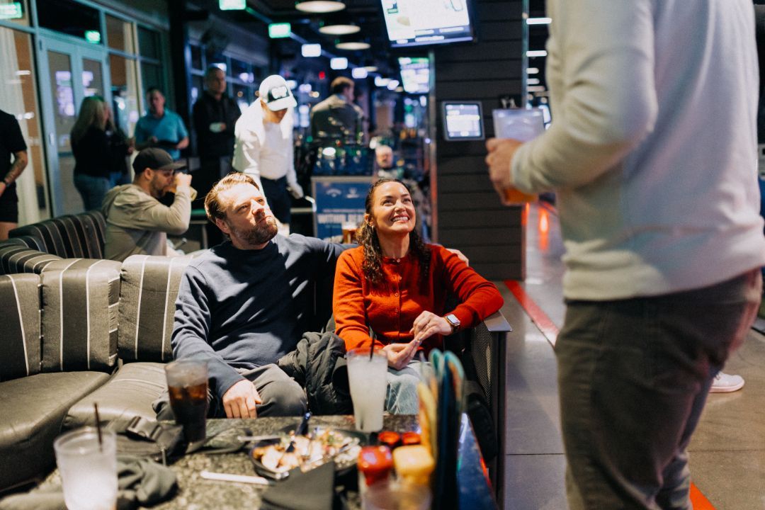 A man and a woman are sitting on a couch in a restaurant.