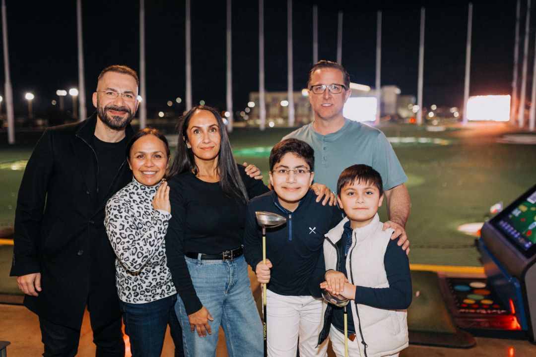 A group of people are posing for a picture on a golf course.