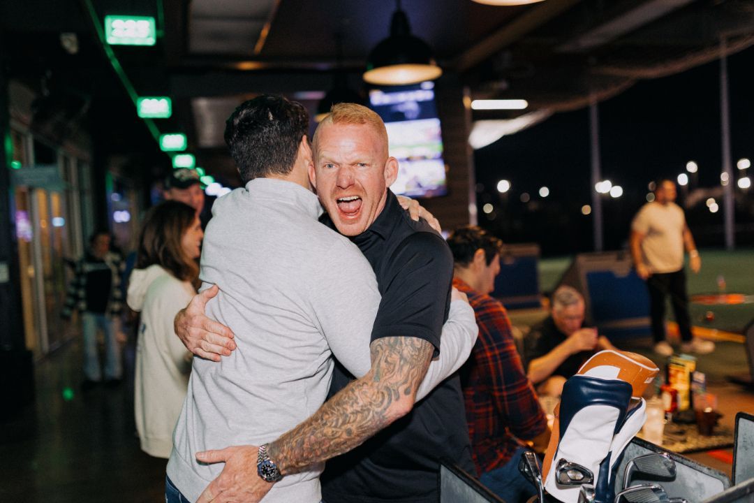 Two men are hugging each other in a restaurant.