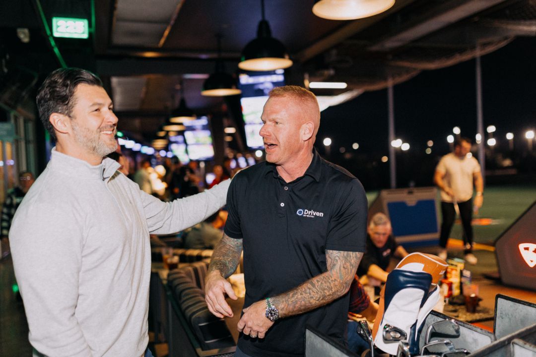 Two men are talking to each other in a restaurant.
