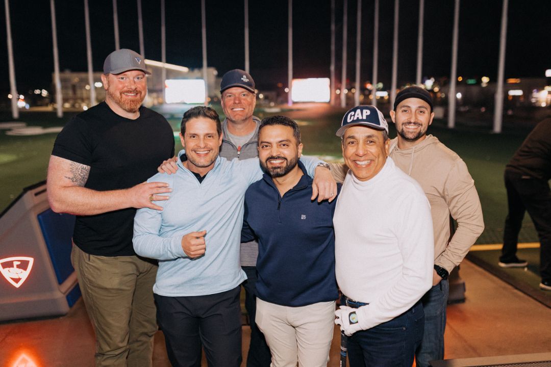 A group of men are posing for a picture on a golf course.