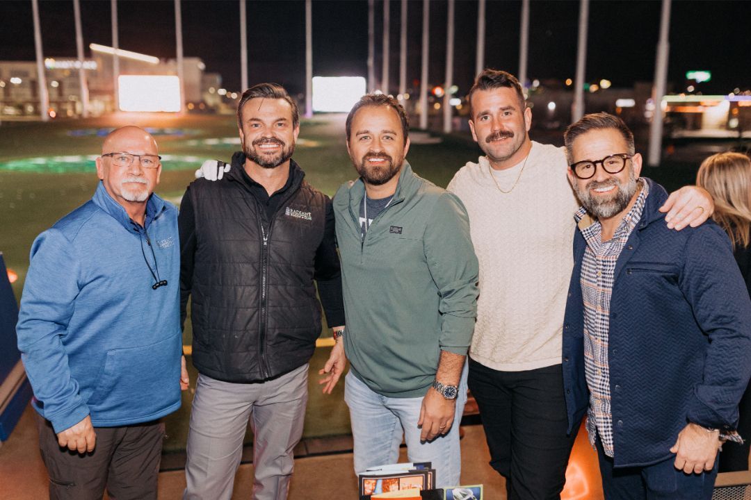 A group of men are posing for a picture together on a golf course.
