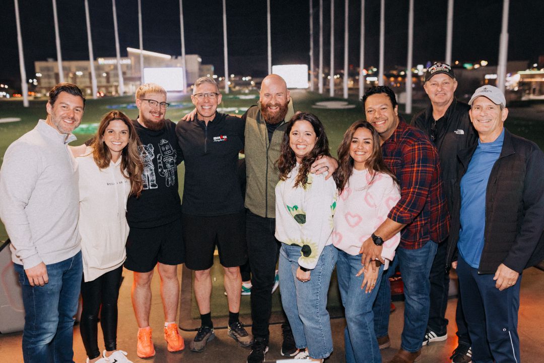 A group of people are posing for a picture on top of a golf course.