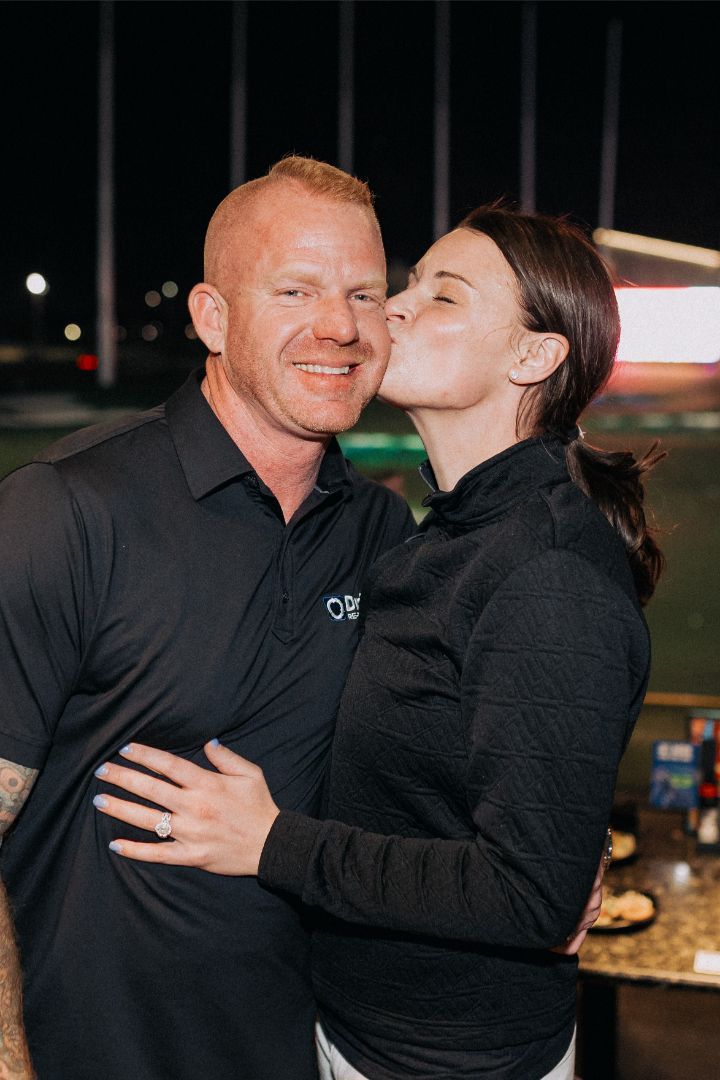 A woman is kissing a man on the cheek.