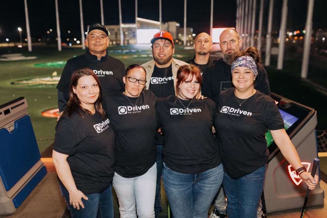 A group of people are posing for a picture at a golf course.