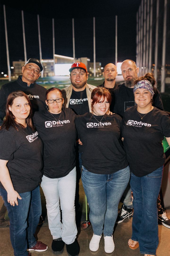 A group of people wearing black shirts are posing for a picture.