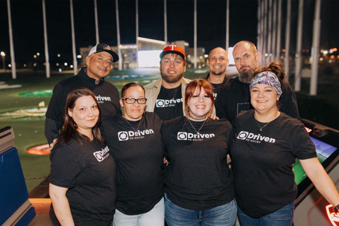 A group of people wearing black shirts are posing for a picture.