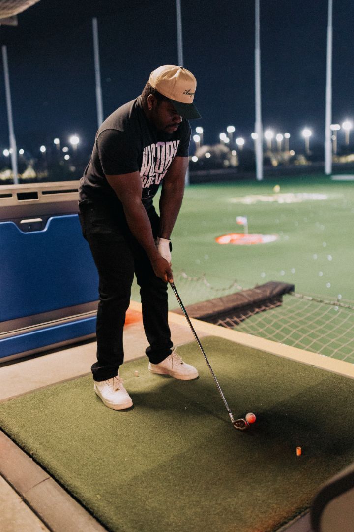 A man is swinging a golf club on a golf course