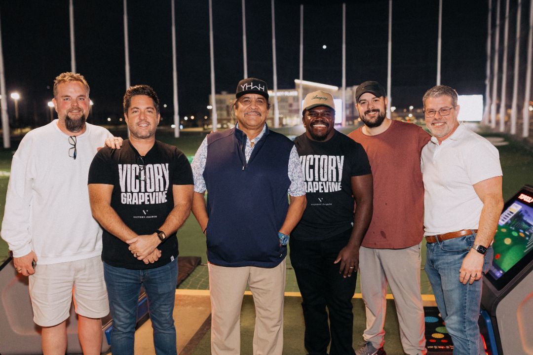 A group of men are posing for a picture on a golf course.