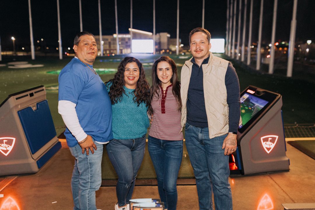 A group of people are posing for a picture at a golf course.