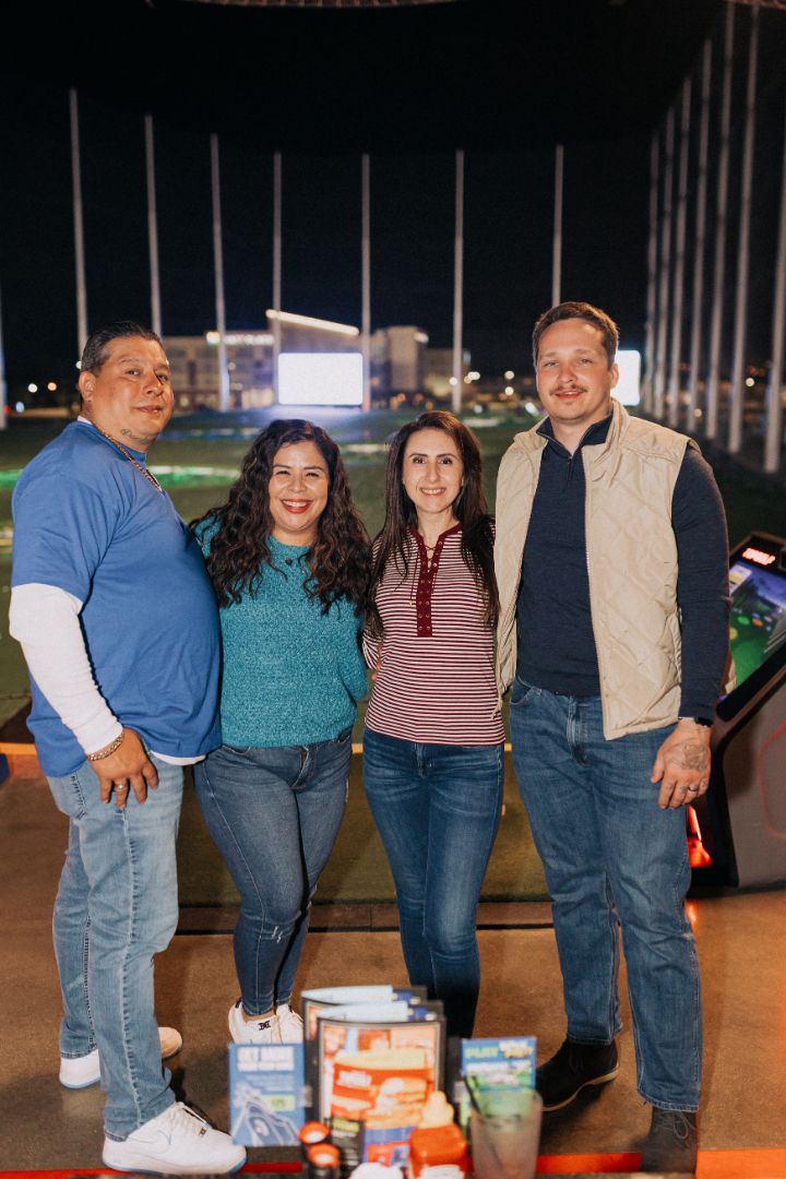 A group of people are posing for a picture at a golf course.