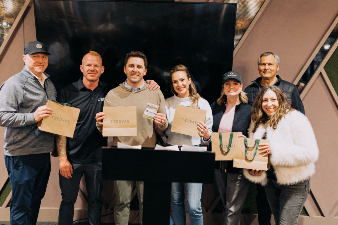 A group of people are standing next to each other holding papers.