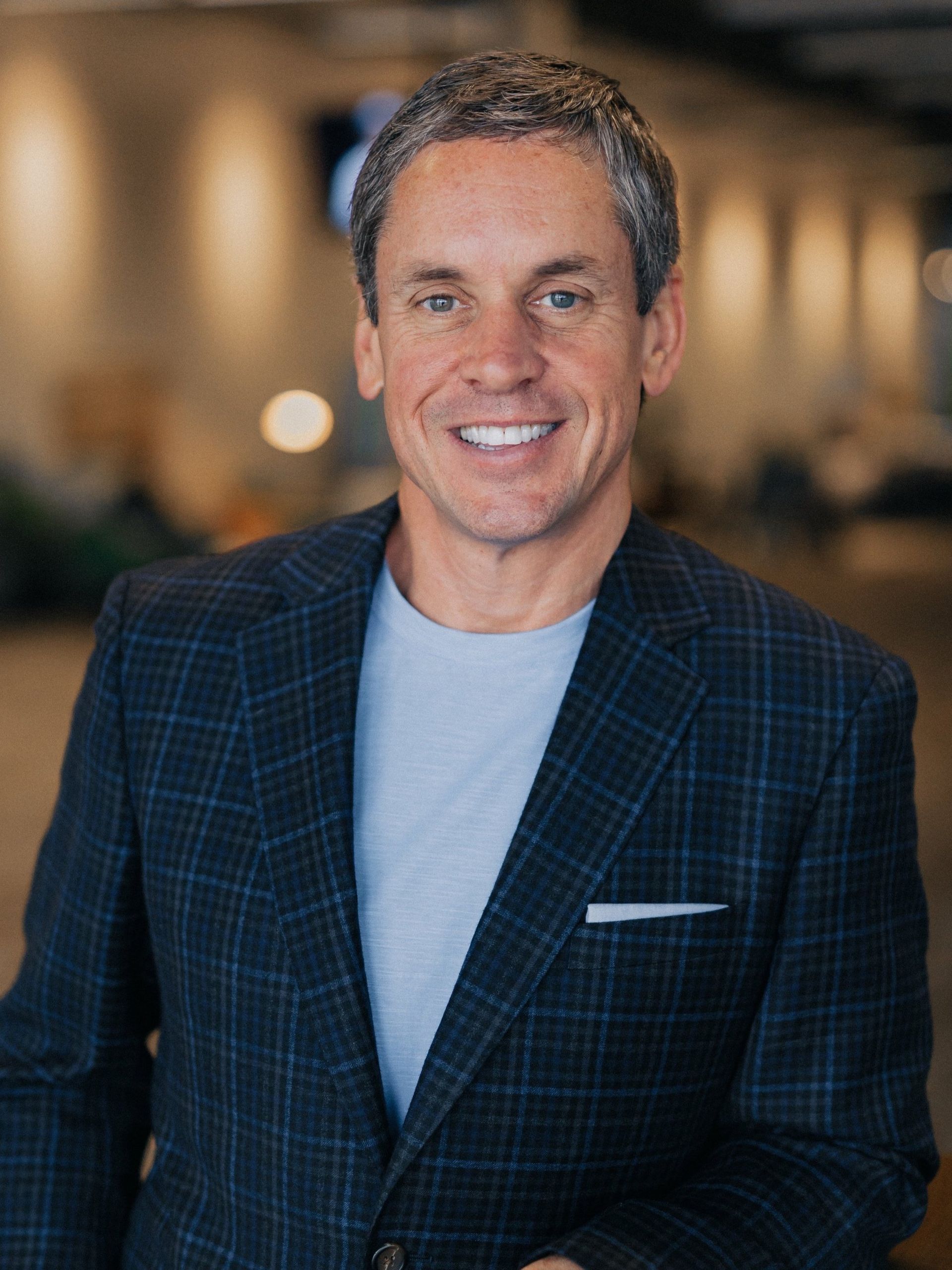A man in a suit and tie is smiling for the camera.