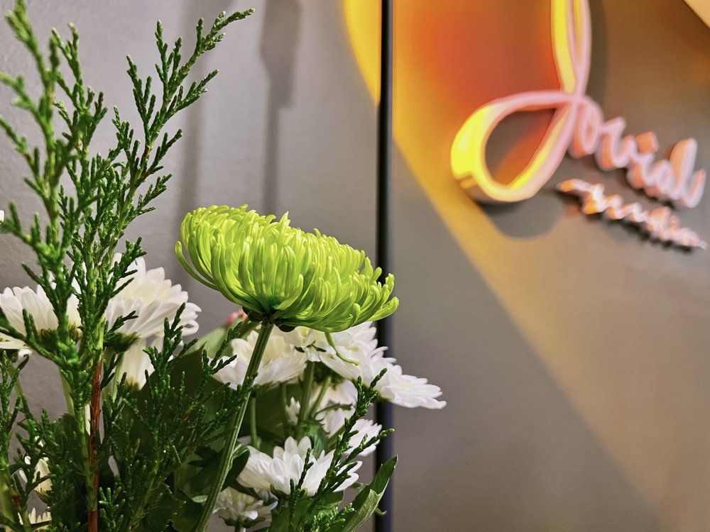 A bunch of flowers in front of a sign that says jovials