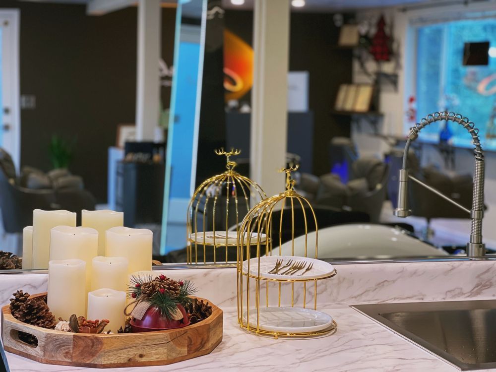A kitchen counter with a wooden tray filled with candles and a sink.