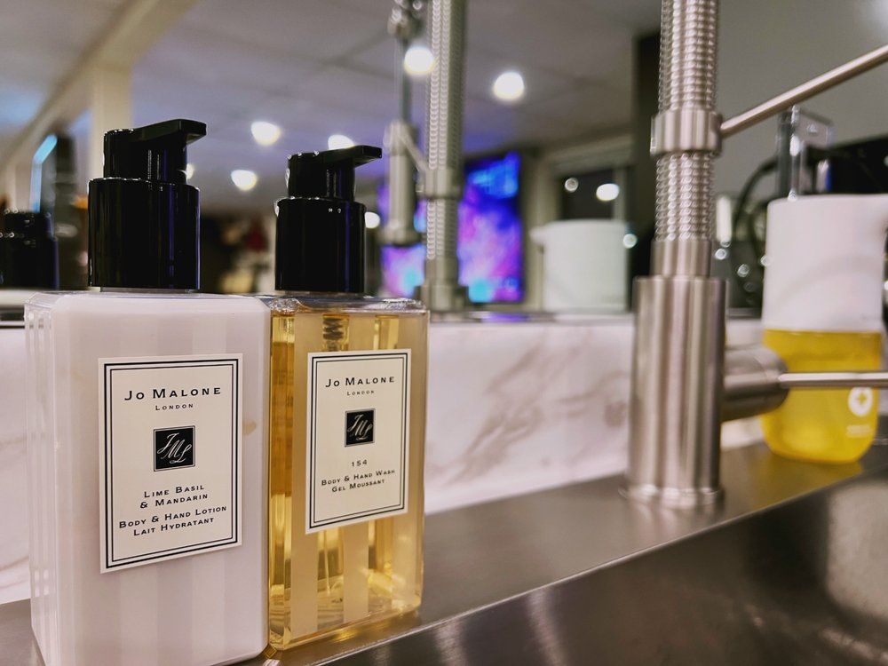 Two bottles of jo malone lotion are sitting on a counter.