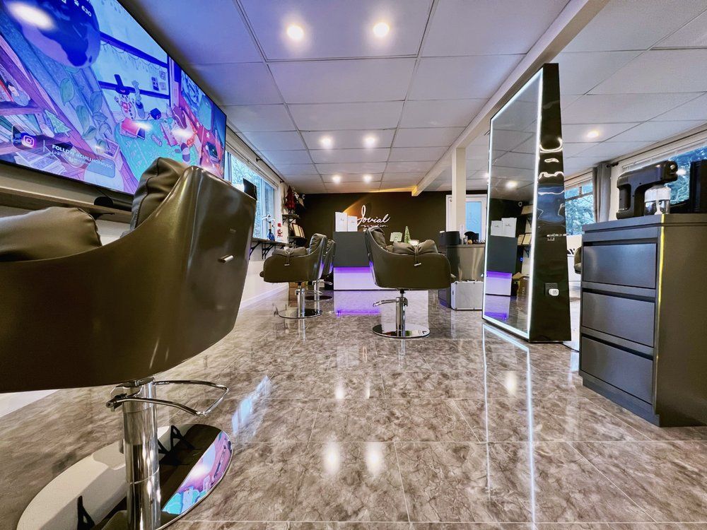 A hair salon with chairs and a large mirror.