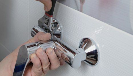 a plumber fitting a new faucet