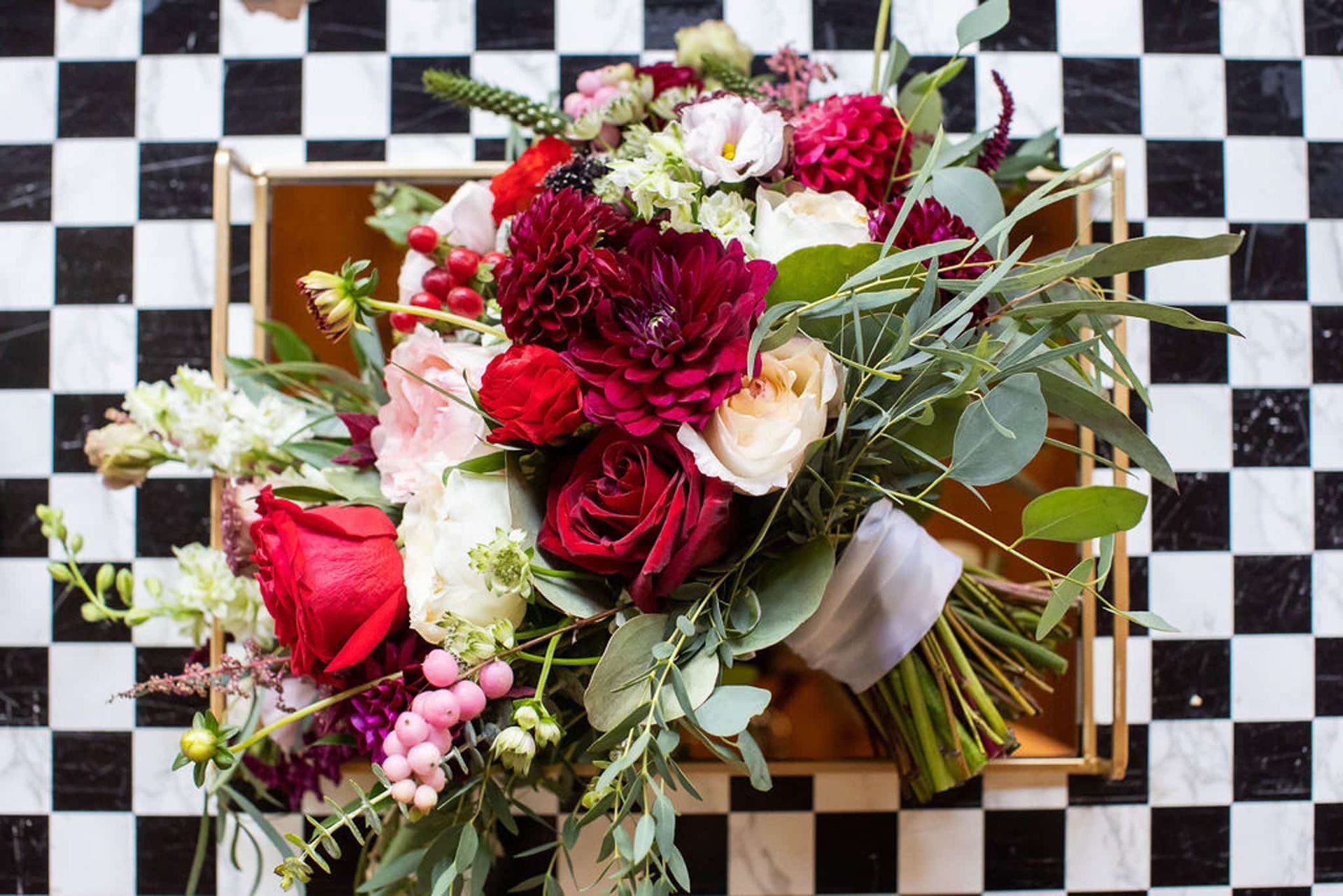 A bouquet of flowers is sitting on a checkered table.