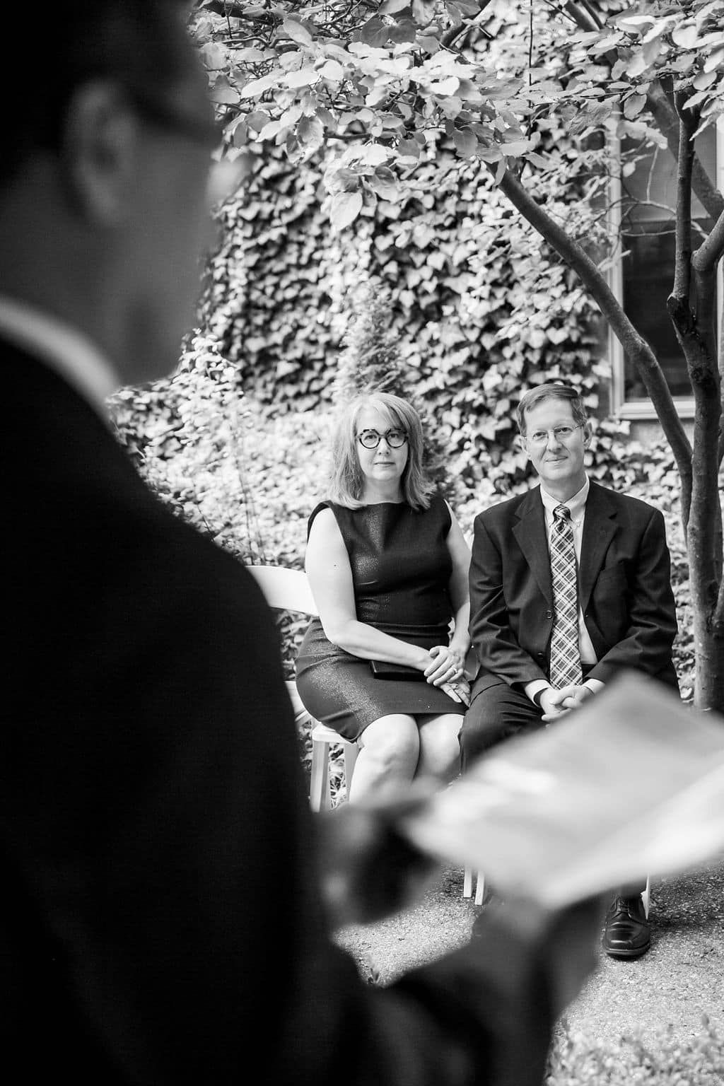A black and white photo of a man giving a speech to a group of people.
