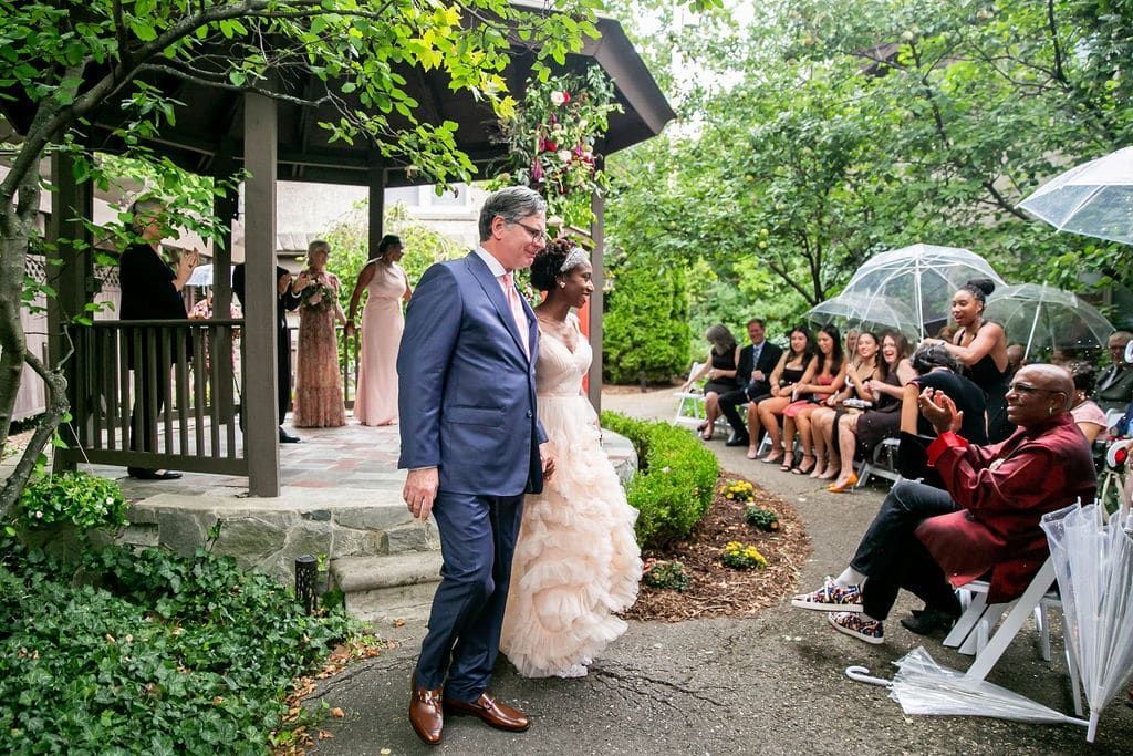 A bride and groom are walking down the aisle at a wedding ceremony.