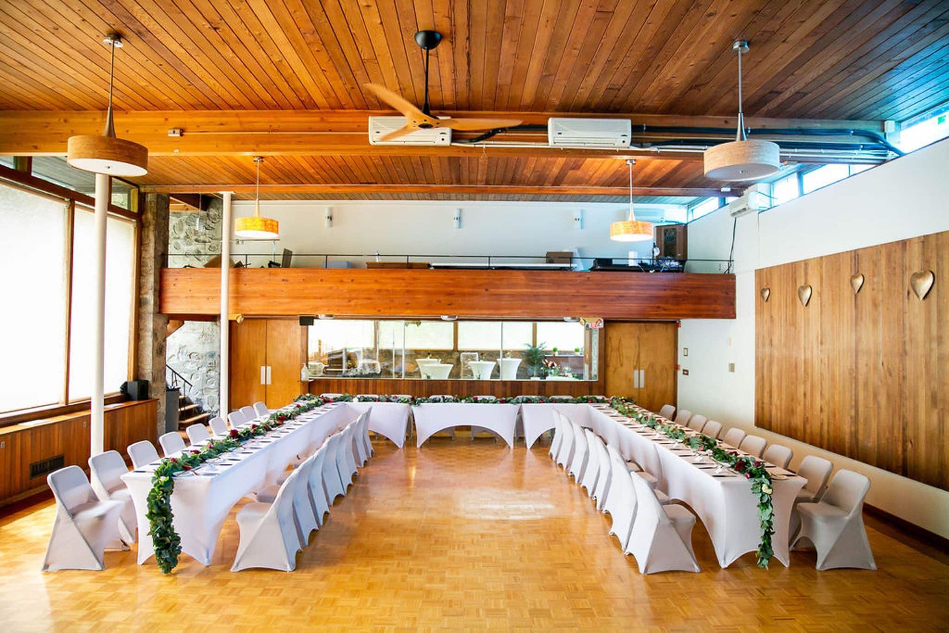A large room with tables and chairs set up for a wedding reception.