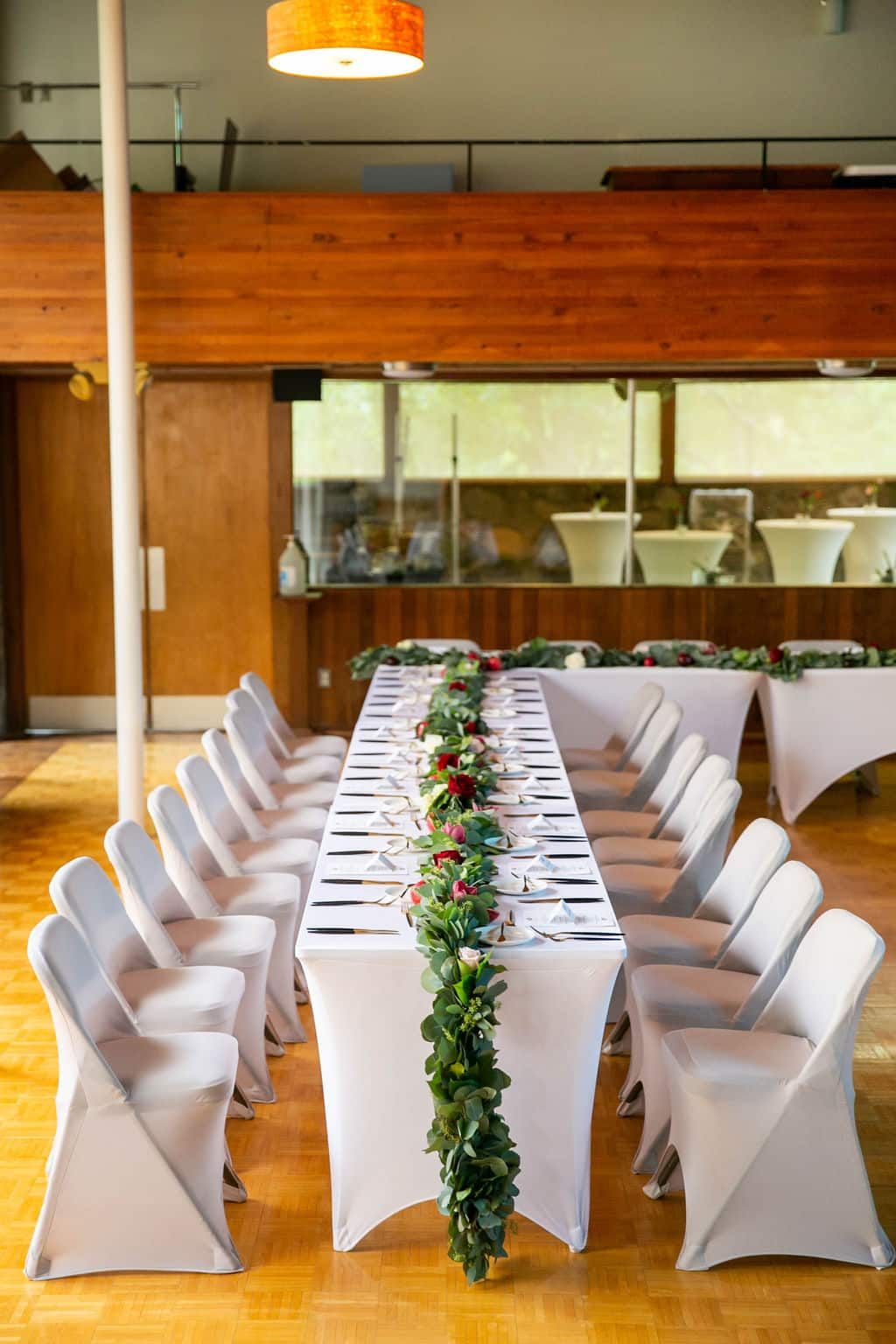 A long table and chairs are set up for a wedding reception.