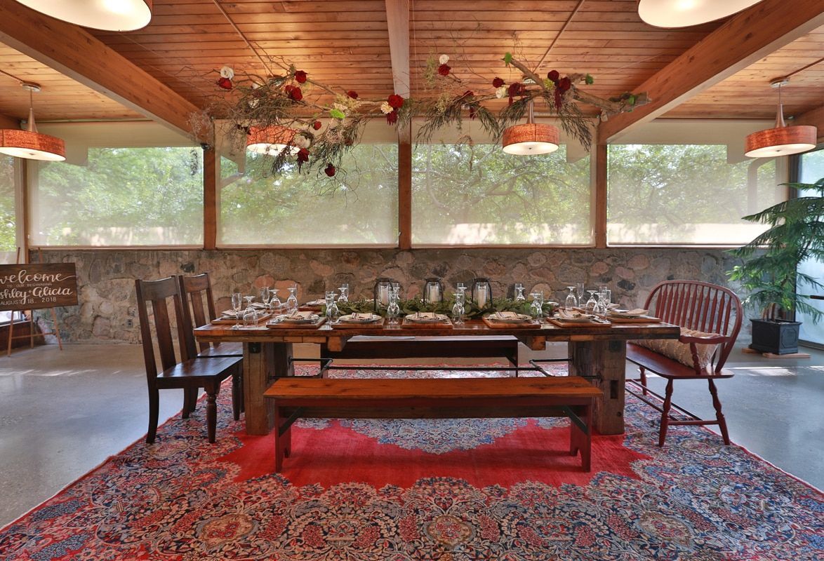 A dining room with a table and chairs and a bench.