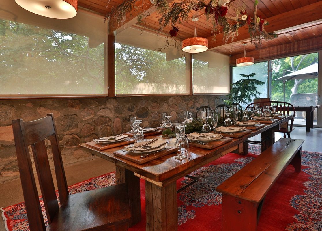 A dining room with a long wooden table and chairs.