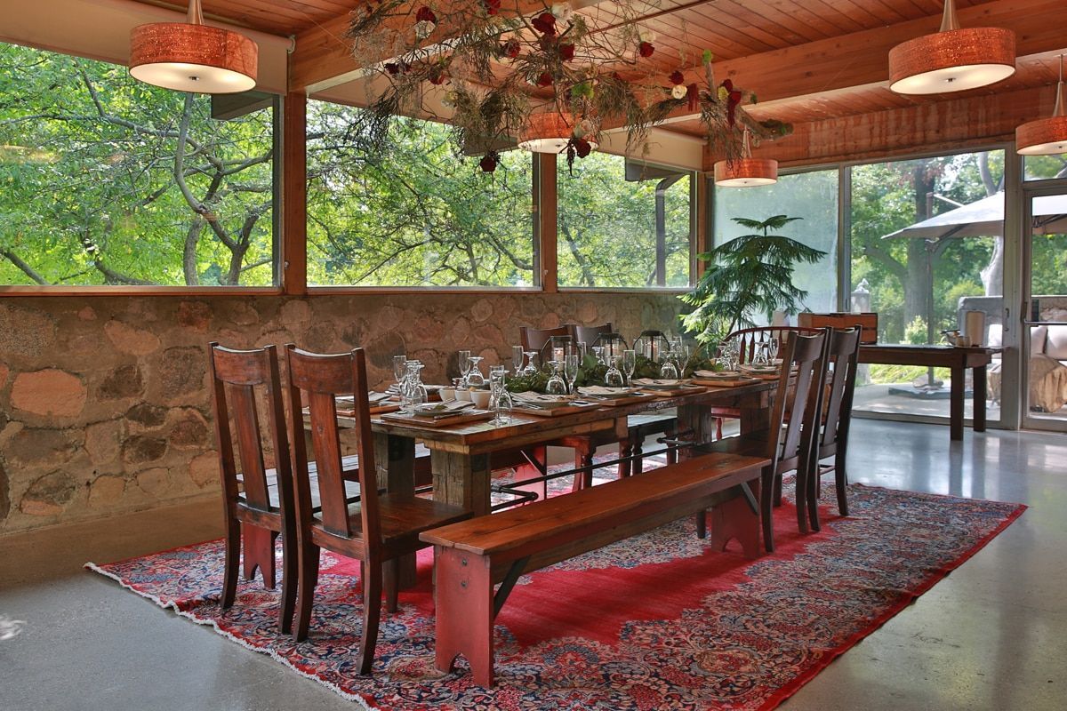 A dining room with a long table and chairs and a bench.