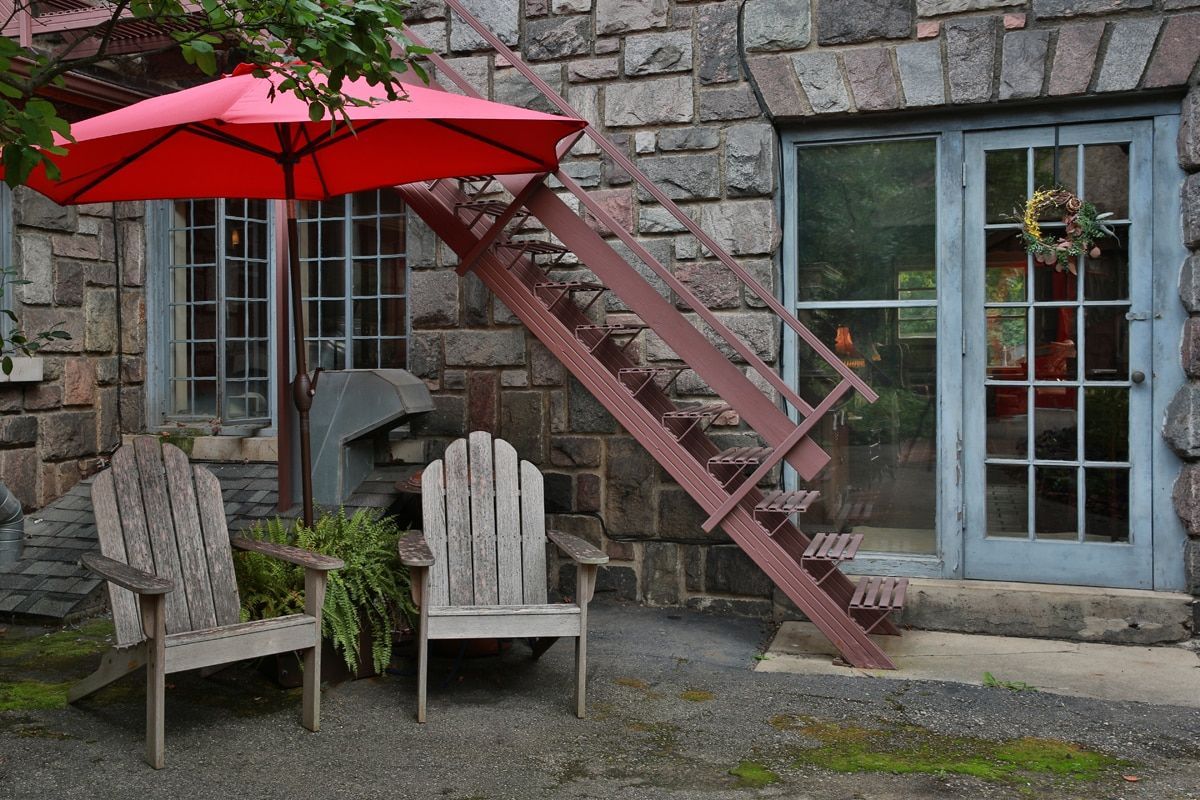 A red umbrella sits in front of a stone building