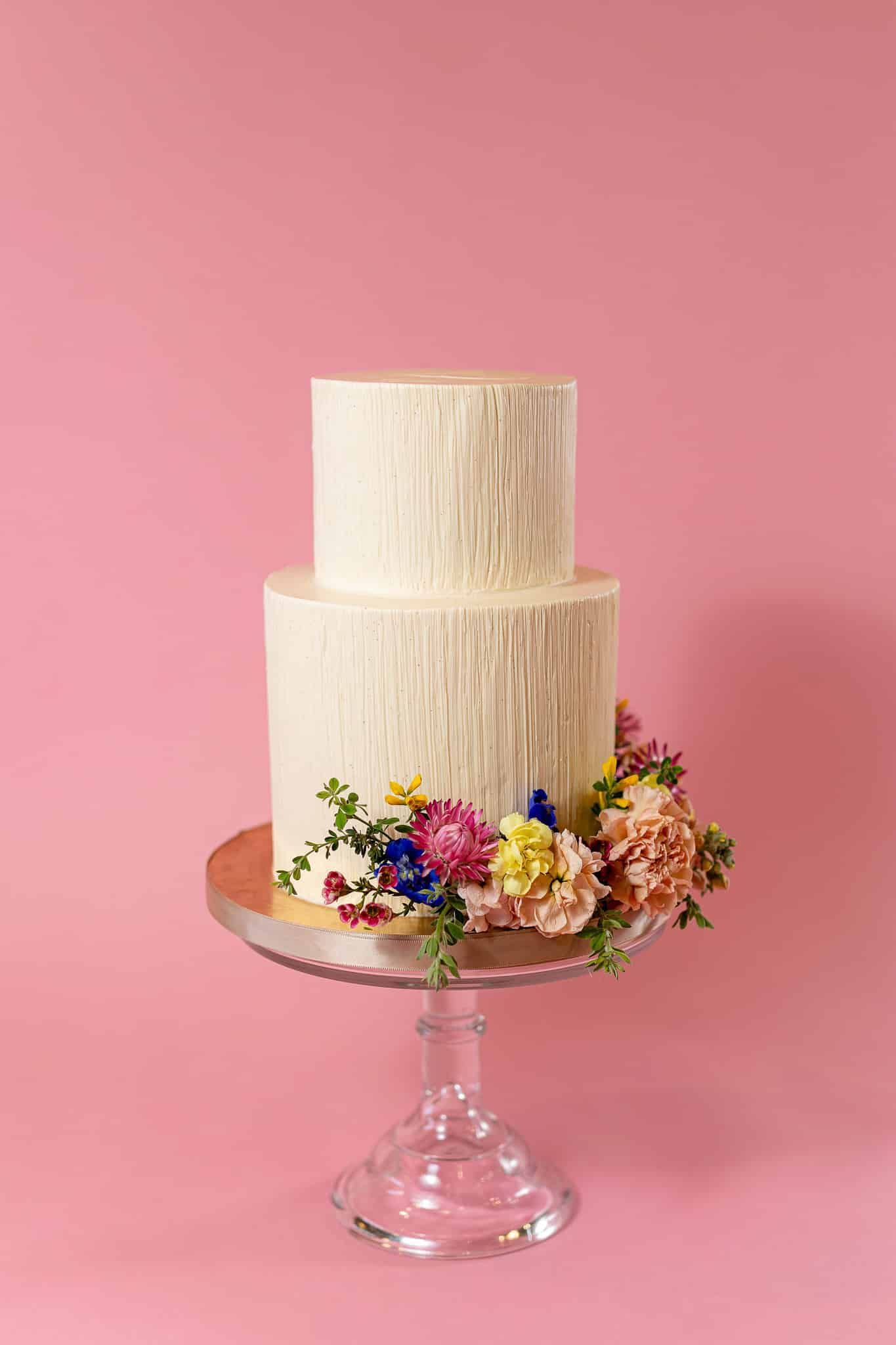 A bride and her bridesmaid are posing for a picture while the bride is holding a bouquet of flowers.