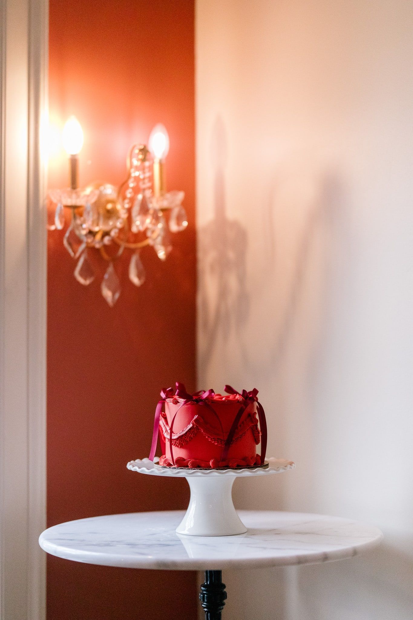 A white table with a red cake on it
