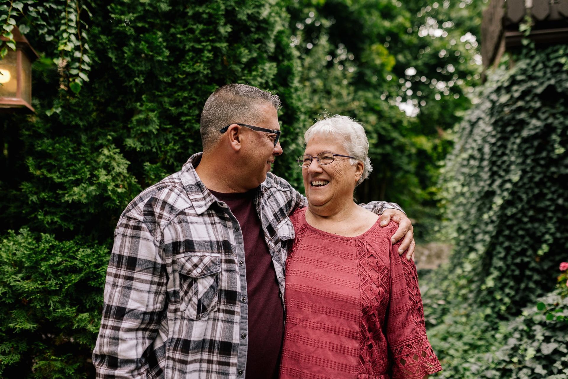 A man and a woman are standing next to each other in a garden.