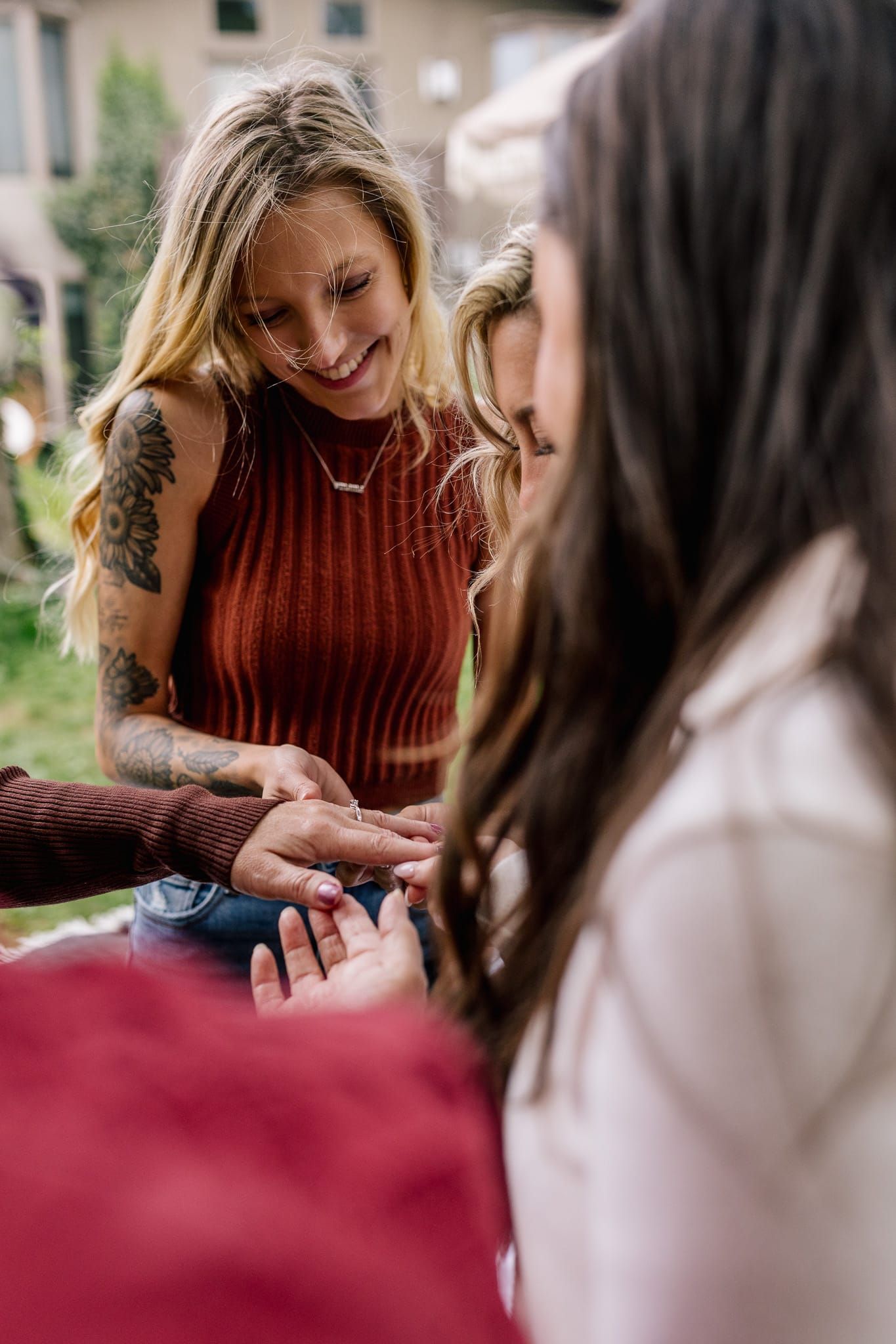 A woman is putting a ring on another woman 's finger.