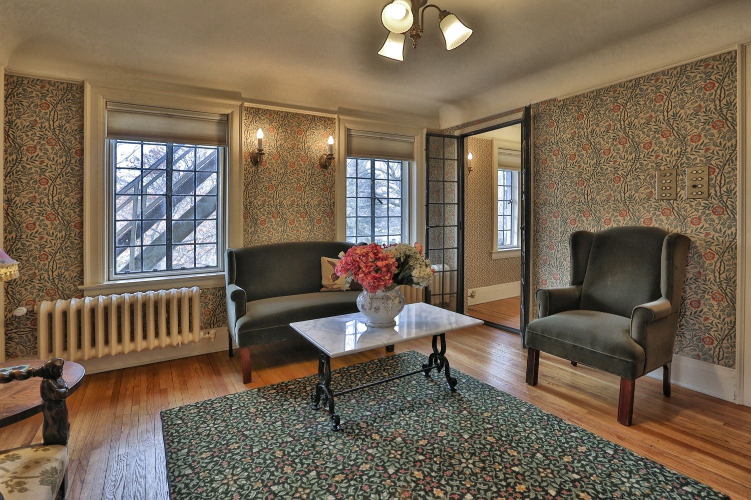 A living room with a couch , chair , coffee table and rug.