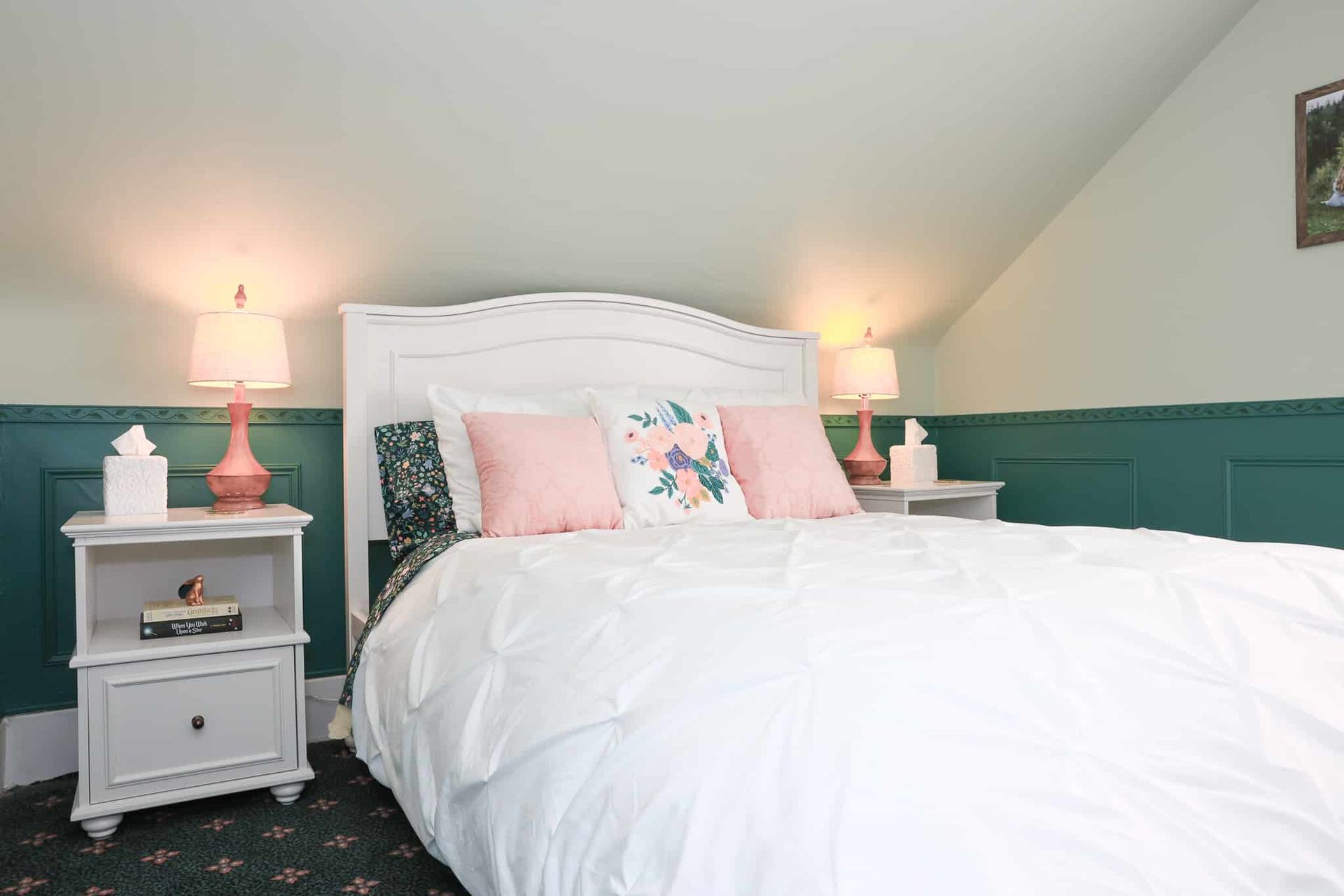 A bedroom with a bed , nightstands , and lamps.