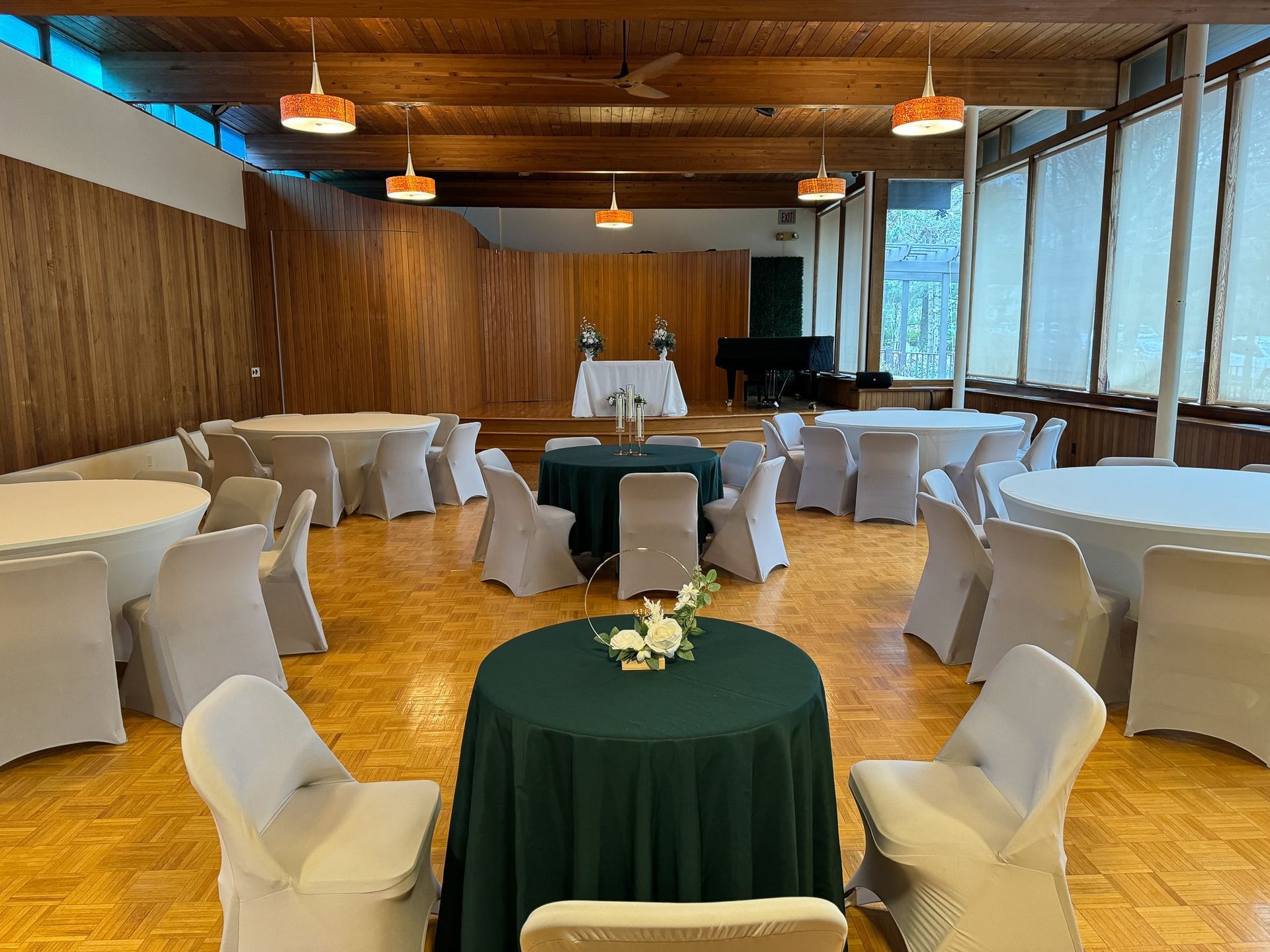 A large room with tables and chairs set up for a wedding reception.