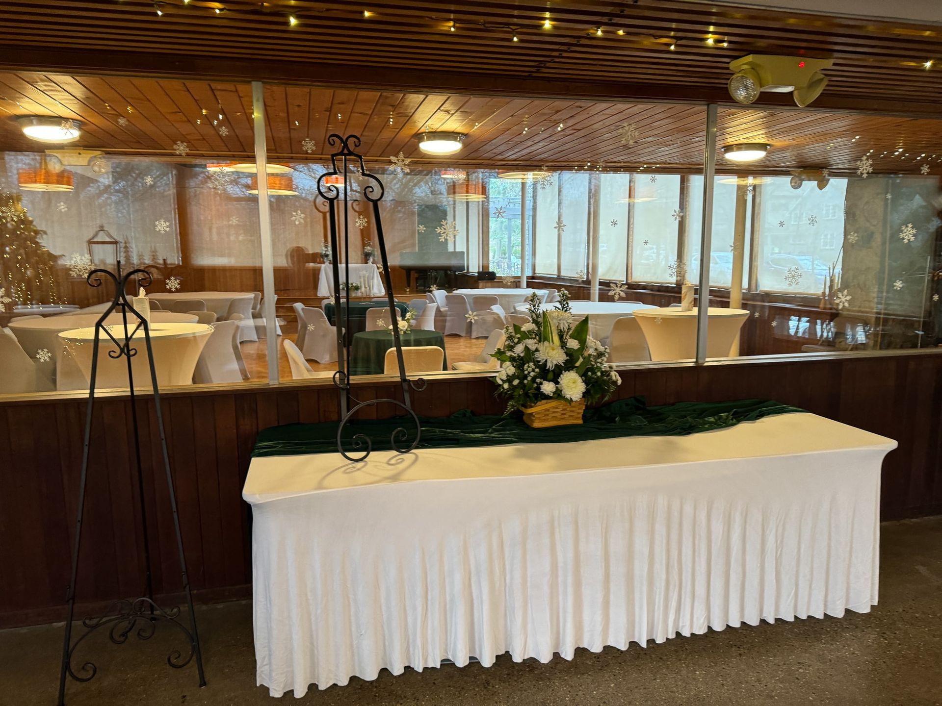 A table with a white table cloth and a vase of flowers on it in a room.