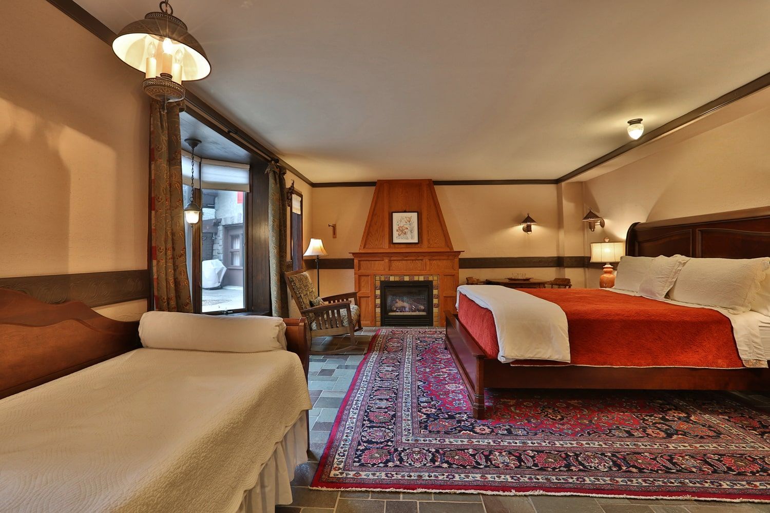 A hotel room with a king size bed and a fireplace